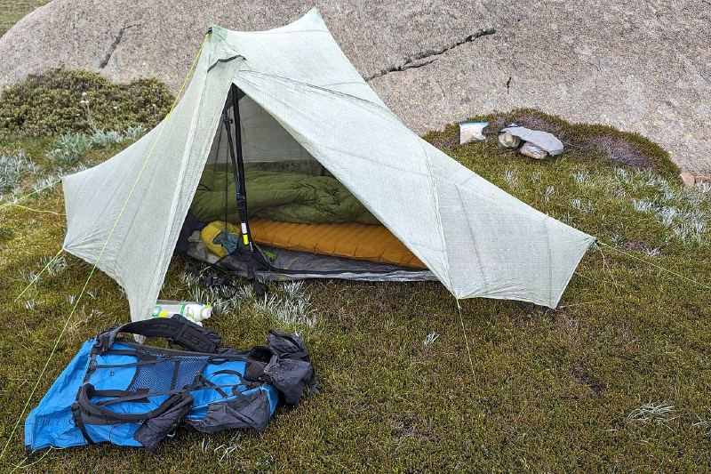 Leichtes Zelt mit Schlafsack und Rucksack auf einer Wiese